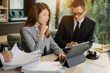 Photo of people sitting at the desk with tablet on it